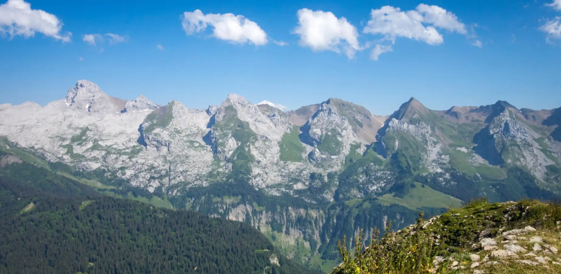 Géomètre-expert réalisant un bornage sur un terrain en pente dans le massif des Aravis en Haute-Savoie