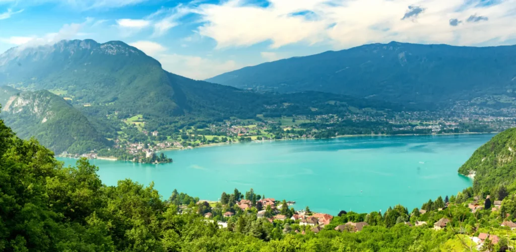 Vue sur le lac d'Annecy depuis un terrain en cours de bornage, massif des Aravis en arrière-plan