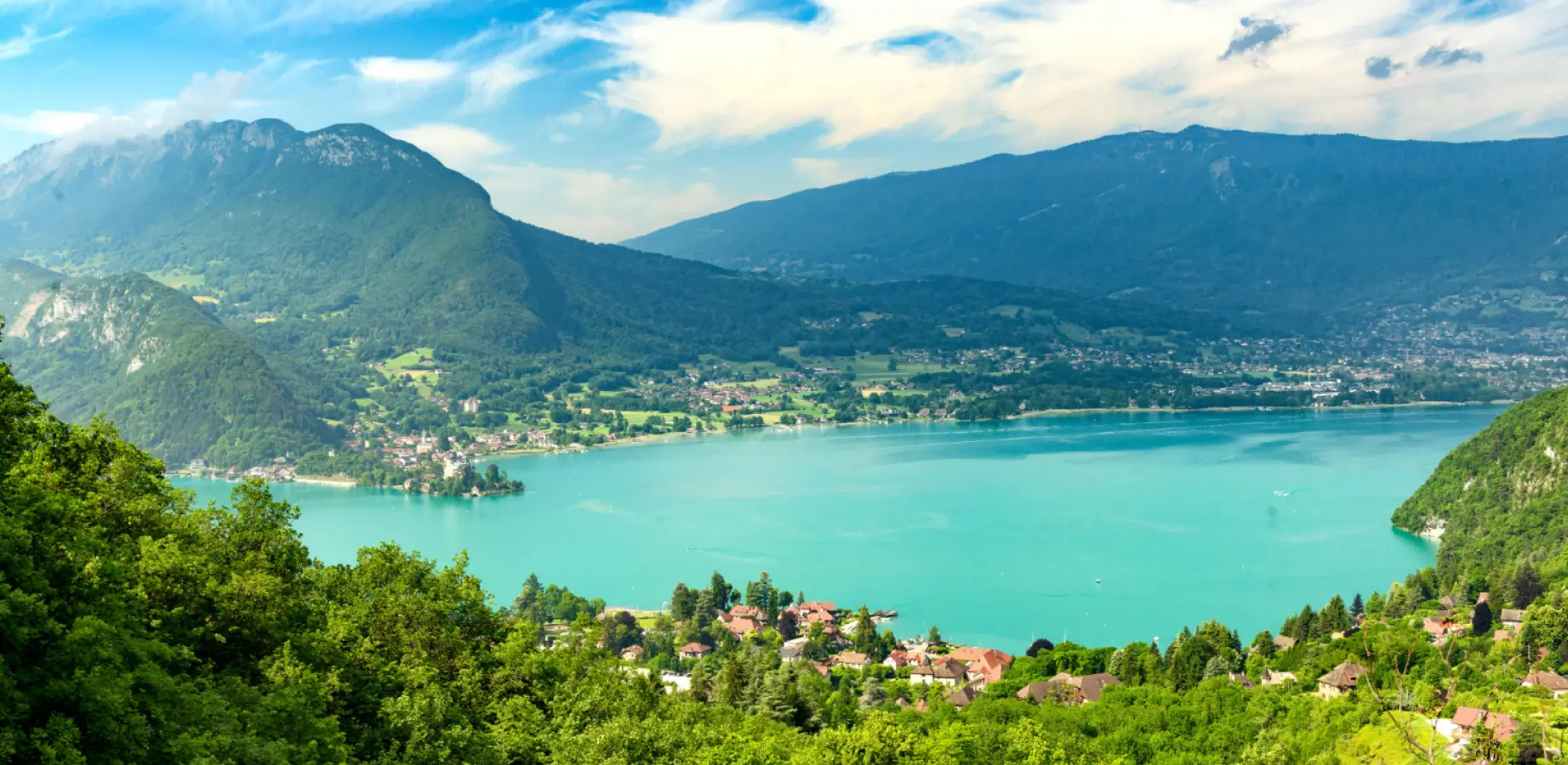 Vue sur le lac d'Annecy depuis un terrain en cours de bornage, massif des Aravis en arrière-plan