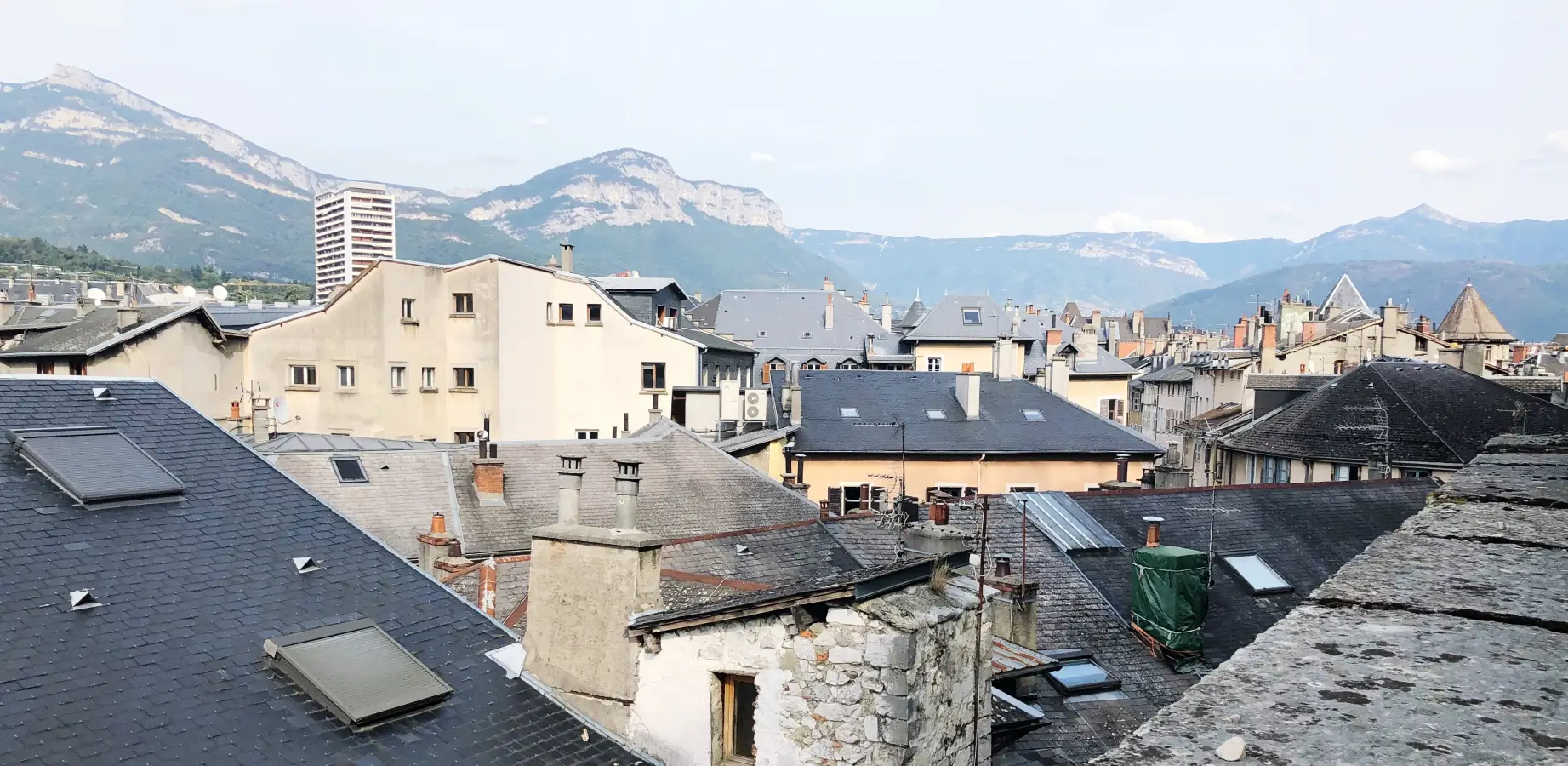 Toits de Chambéry vus de près, avec les reliefs du massif des Bauges en arrière-plan